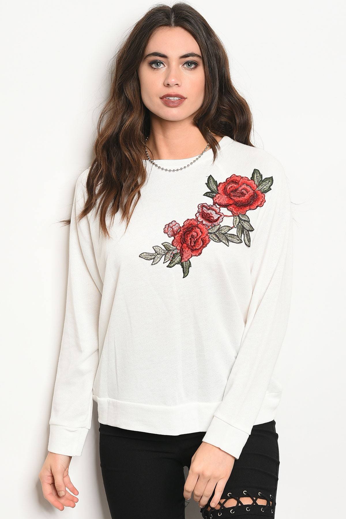Ladies fashion long sleeve light weight knit top with a crew neckline and floral patch details