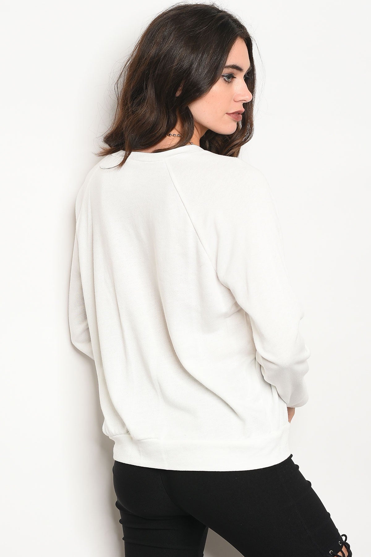 Ladies fashion long sleeve light weight knit top with a crew neckline and floral patch details