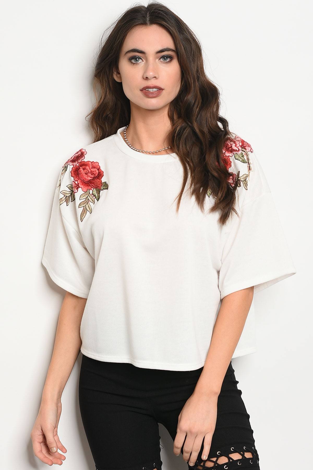 Ladies fashion 3/4 sleeve light weight knit top with a crew neckline and floral patch details