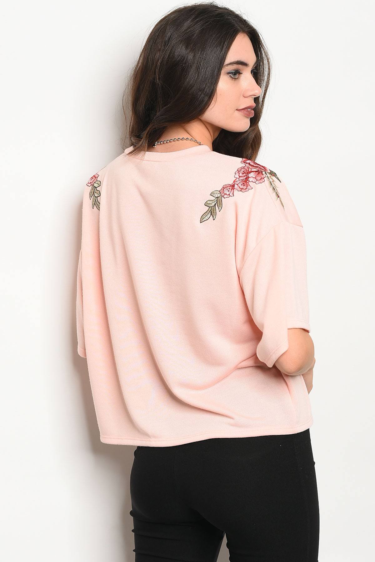Ladies fashion 3/4 sleeve light weight knit top with a crew neckline and floral patch details